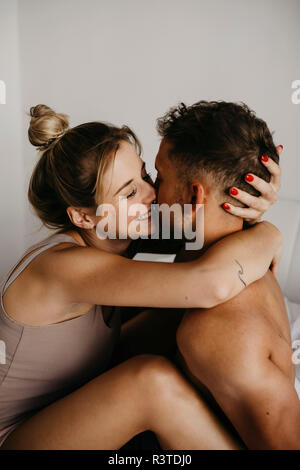 Felice coppia giovane costeggiata a letto Foto Stock