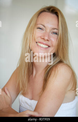 Ritratto di una donna sorridente, avvolto in asciugamano Foto Stock