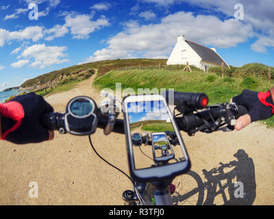 Francia, Bretagne, Sainte-Anne La Palud, Plage de Treguer, telefono cellulare sulla montagna e-bike Foto Stock