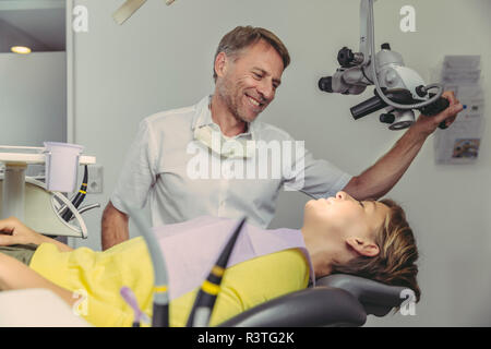 Dentista esaminando il suo paziente, mediante microscopio dentale Foto Stock