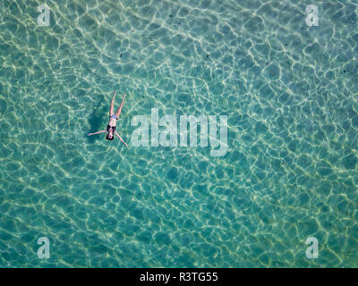 Indonesia, Bali, Melasti, vista aerea del Karma Kandara beach, donna galleggiante sull'acqua Foto Stock