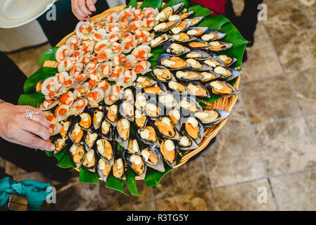 Vassoio di cozze cotte con spezie servito ad una festa gastronomica. Foto Stock