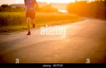 Atleta maschio/runner in esecuzione su strada - jog allenamento benessere concept Foto Stock