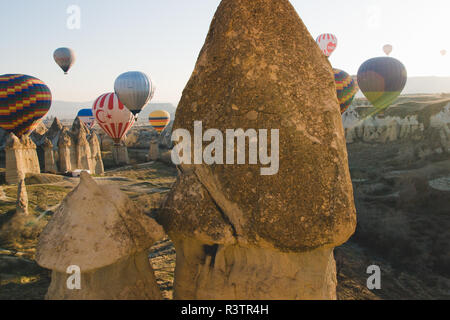Goreme, Turchia - Aprile 4, 2012: i palloni ad aria calda per i turisti volare sopra le formazioni rocciose a sunrise nella valle della Cappadocia. Foto Stock