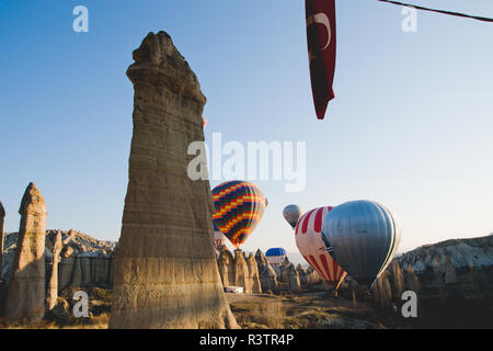 Goreme, Turchia - Aprile 4, 2012: i palloni ad aria calda per i turisti volare sopra le formazioni rocciose a sunrise nella valle della Cappadocia. Foto Stock
