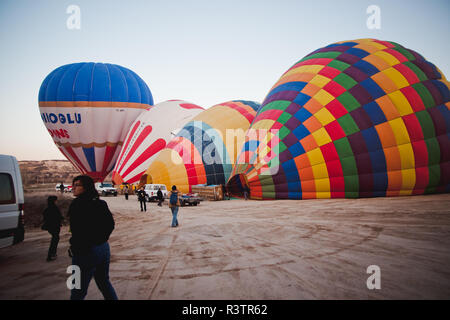 Goreme, Turchia - Aprile 4, 2012: i palloni ad aria calda per i turisti volare sopra le formazioni rocciose a sunrise nella valle della Cappadocia. Foto Stock