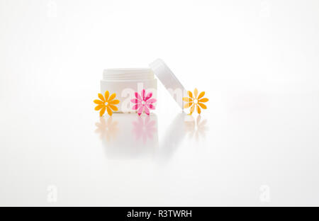 Aperto un vasetto di crema con fiori di colore rosa e arancio Foto Stock