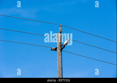 Vecchio semplice legno rurale polo elettrico sul cielo blu Foto Stock