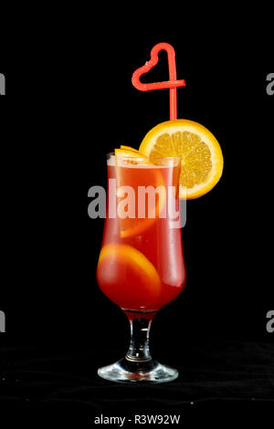 Cocktail alcolico con limoni interno e cuneo limone sul vetro con paglia isolato con sfondo nero Foto Stock