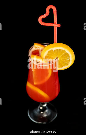 Cocktail alcolico con limoni interno e cuneo limone sul vetro con paglia isolato con sfondo nero Foto Stock