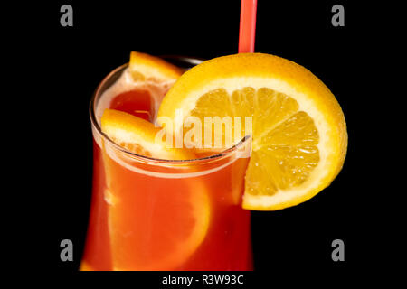 Cocktail alcolico con limoni interno e cuneo limone sul vetro con paglia isolato con sfondo nero Foto Stock