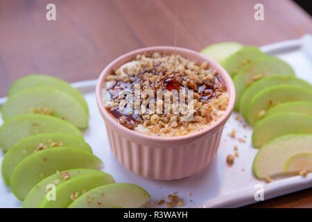 Caramel Apple Dip con dadi, caramello medicazione e freschi fette di mela su legno Foto Stock