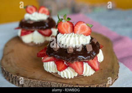 Pavlova al cioccolato con fragole e panna montata su legno Foto Stock