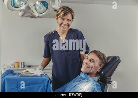 Chirurgo dentista parlando al paziente prima del trattamento Foto Stock