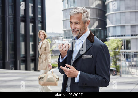 Germania, Duesseldorf, ritratto di maturo imprenditore parlando al telefono cellulare Foto Stock