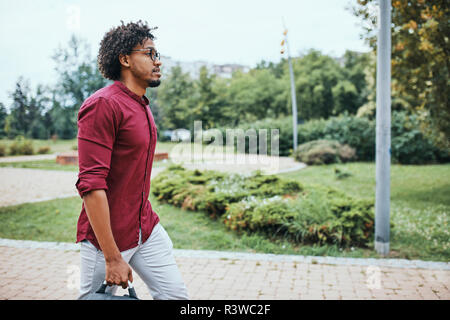 Giovane uomo di andare al lavoro, borsa per il trasporto Foto Stock