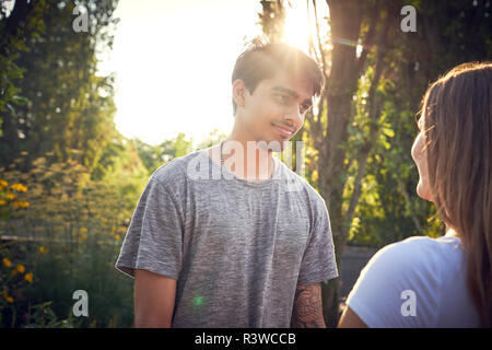 Felice coppia giovane flirtare in un parco in estate Foto Stock