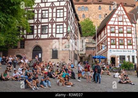 La gente seduta in Piazza Tiergartnertor, Norimberga, Baviera, Germania Foto Stock