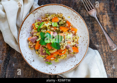 Orzo perlato e pancetta cassarole con carote, porri e cavolo verza - vista superiore Foto Stock