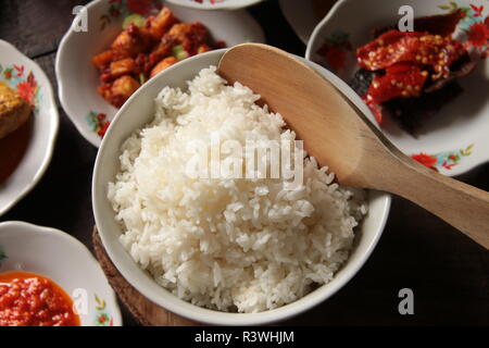 Nasi Putih. Una grande ciotola di il riso bianco cotto a vapore per diversi diners, servita presso un ristorante di Padang. Foto Stock