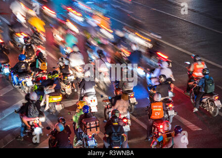 BANGKOK, Tailandia - 31 Luglio: motion blur di motociclette di attraversare una strada trafficata nell'area del centro cittadino di notte sulla luglio 31, 2018 a Bangkok Foto Stock