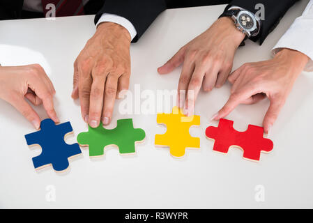 Persone assemblaggio di pezzi di un puzzle Foto Stock