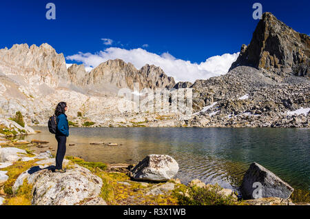 Escursionista sotto il picco isoscele e Palisades nel bacino Dusy, Kings Canyon National Park, California, Stati Uniti d'America (MR) Foto Stock