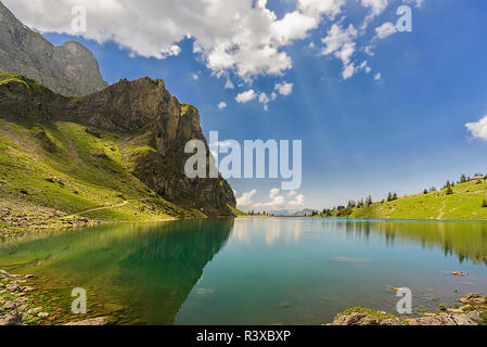 Riflettendo sulle montagne in luce posteriore Foto Stock