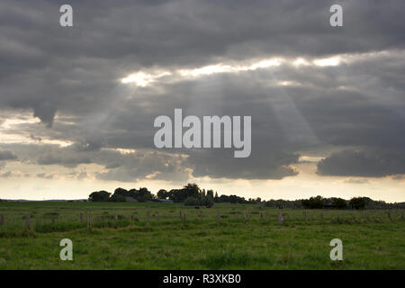 Il sole fa capolino tra le nuvole sopra un agriculturally area utilizzata nella Renania settentrionale-Vestfalia (Germania). Foto Stock