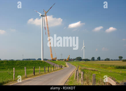 Sito di costruzione di una nuova turbina eolica, uno vecchio in background. Foto Stock