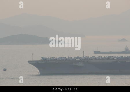 Hong Kong. Il 24 novembre 2018. L'immagine rappresenta la portaerei USS Ronald Reagan (CVN 76) ancorata vicino a sud di Tsing Yi Island in Hong Kong con alcune piccole imbarcazioni vicino a lei, la foto è stata scattata durante il tramonto il 24 novembre 2018. Credito: Kit Chun Li/Alamy Live News Foto Stock