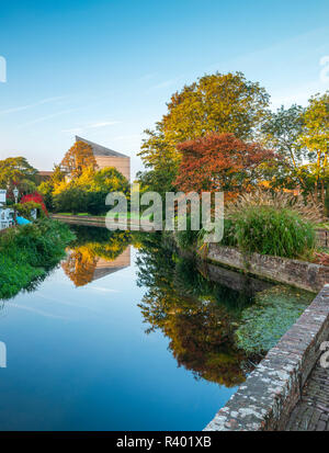 Abbots Mill Garden a Canterbury con il Marlowe Theatre si riflette nel fiume Stour dietro. Foto Stock