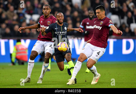 Manchester City's Raheem Sterling (centro) battaglie per la palla con il West Ham United's Issa Diop (sinistra) e Fabian Balbuena durante il match di Premier League al London Stadium, Londra. Foto Stock