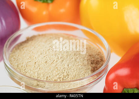 Il lievito nutrizionale circondato da altri ingredienti freschi per vegano cremoso i peperoni e le cipolle. Foto Stock