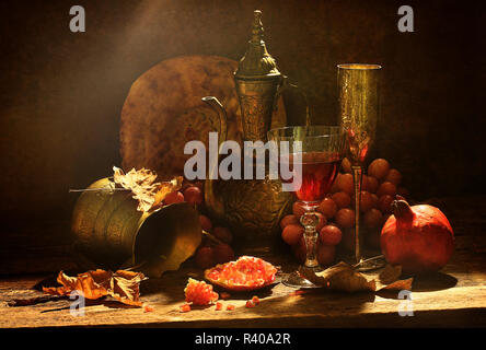 Ancora vita in stile orientale con uve, melograno e vino Foto Stock
