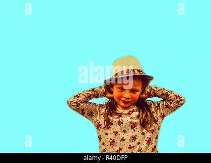 Bambina su sfondo colorato. Spazio di copia. La ragazza indossa un cappello di paglia e un abito fiorito. Sfondo blu chiaro Foto Stock