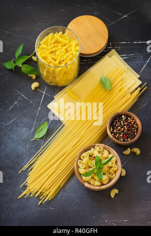 Varie la pasta. Ingredienti per la cottura della pasta su un tavolo di pietra. Copia dello spazio. Foto Stock