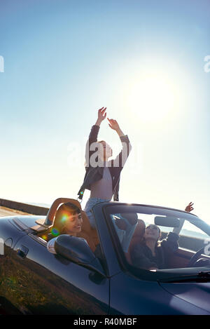 Ritratto di tre piuttosto giovani donne in marcia su una strada viaggio sulla bella giornata d'estate. Foto Stock