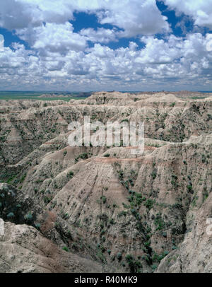 Stati Uniti d'America, Sud Dakota, Parco nazionale Badlands, unità del Nord, Cumulus nubi galleggiare sopra morbido, eroso formazioni sedimentarie, vicino Norbeck Pass. Foto Stock