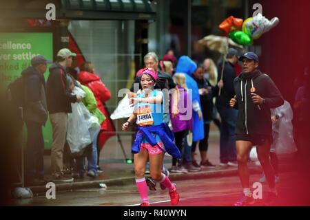 Chicago, Illinois, Stati Uniti d'America. Un colorato partecipante, con una bandiera di Taiwan accorata sulla sua guancia, controlli il suo tempo durante la Maratona di Chicago. Foto Stock