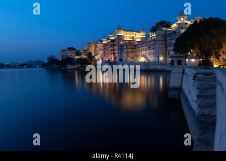 Vista di FATEH PRAKASH PALACE si affaccia e riflettendo nel bellissimo lago Pichola di notte. Udaipur, Rajasthan, India Foto Stock