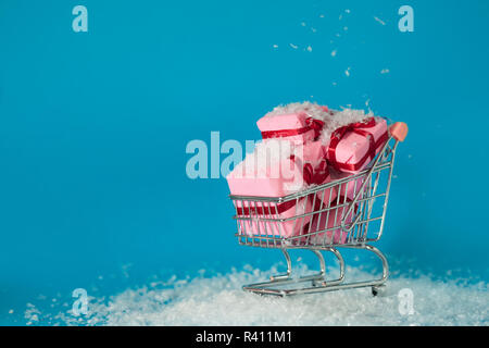 Shopping di Natale sul sito. Ricerca di regali di Natale per tutta la famiglia, concept Carrello Il carrello è pieno di confezioni regalo Foto Stock