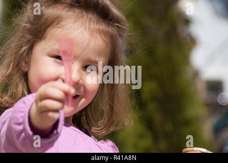 Una bambina orgogliosamente tenendo la sua eislÃ¶ffel alta Foto Stock