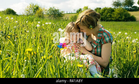 La madre consola la figlia su un prato a molla - parte 3 Foto Stock