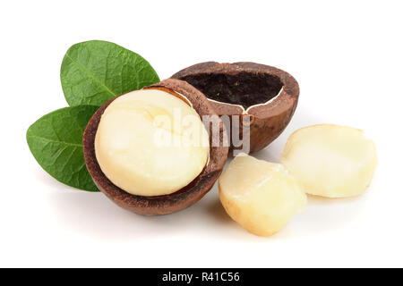 Decorticate noci macadamia con foglie isolati su sfondo bianco Foto Stock