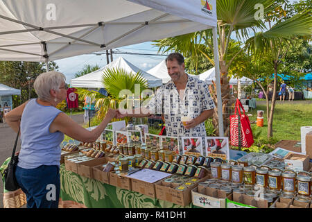 Il capitano Cook, Hawaii - un fornitore offre un assaggio di localmente-cresciute marmellata alla pura Kona Green Market. Foto Stock