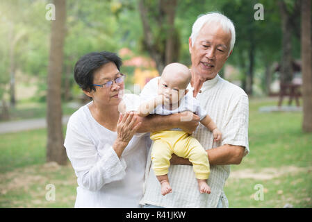 Il cinese nonno e la nonna a giocare con il bambino nipote a outdoor Foto Stock