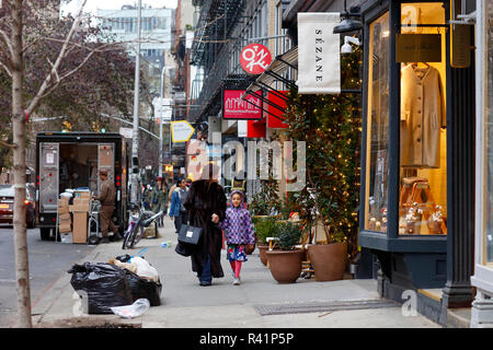 Persone che camminano giù Elizabeth Street con le sue molte piccole boutique e negozi di moda nel Quartiere Nolita di Manhattan, New York, NY Foto Stock