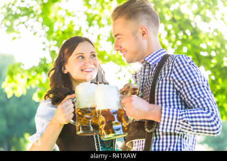 Deutsches Paar in Tracht trinkt Bier Foto Stock