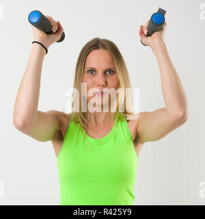 Sorridente donna bionda facendo esercizi con pesi Foto Stock